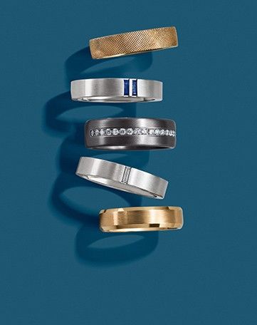 Assortment of gold, gemstone, and alternative metal men’s wedding rings.